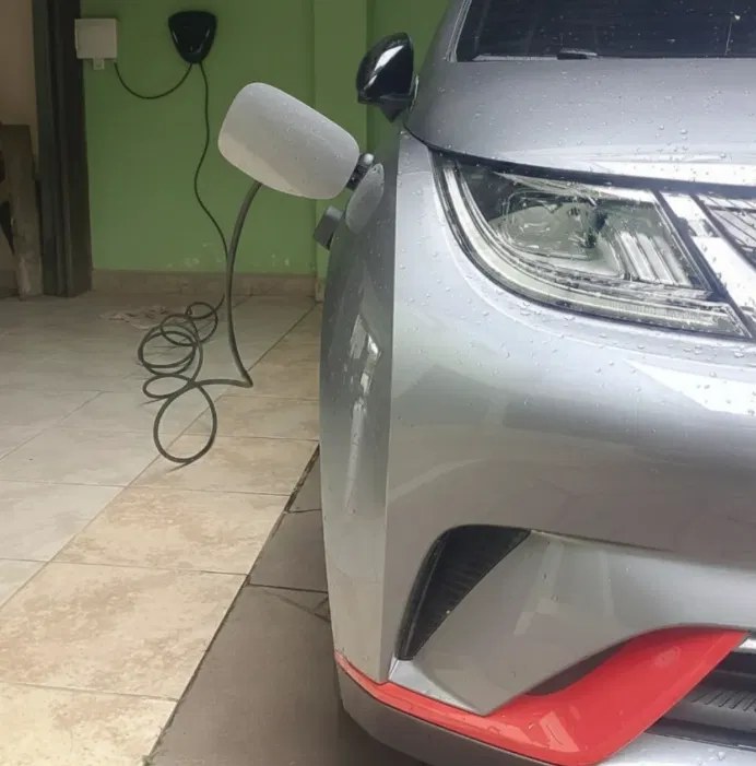 Carro elétrico carregando em wallbox instalado na garagem
